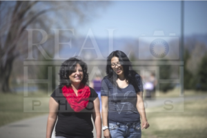 Two Hispanic Women Walking and Talking Outside